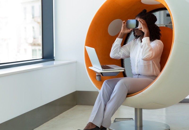 Female office employee with laptop watching virtual presentation